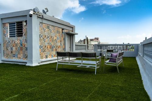 a patio with two chairs and a table on a roof at Navona Studios in San Juan