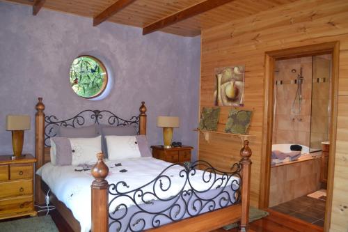 una camera da letto con un letto e una parete di legno di Whispering Spirit Holiday Cottages & Mini Ponies a Franklin
