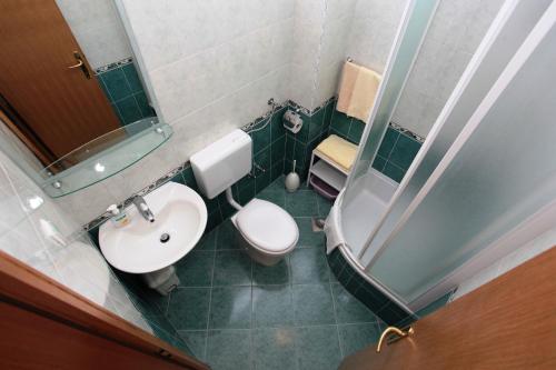 a small bathroom with a toilet and a sink at Apartments Akmadzic in Makarska