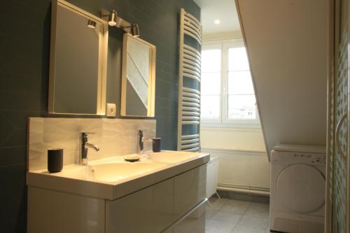 een badkamer met een wastafel en een spiegel bij Sunset Dieppe in Dieppe