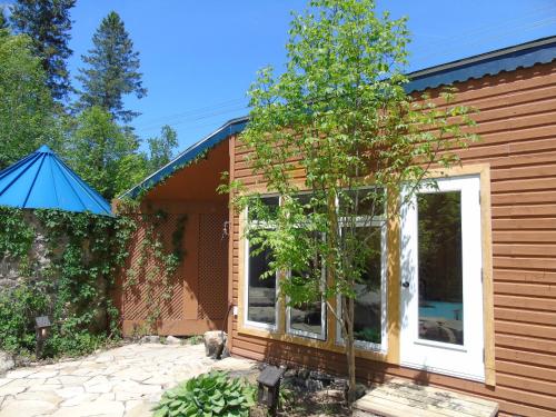 a house with a tree in front of it at Auberge Spa & Beaux Reves in Sainte-Adèle