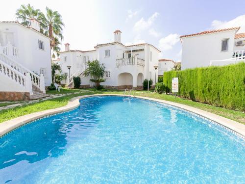 Casas DevesaにあるApartment Club Sevilla I by Interhomeの白い家2軒の前の大きなスイミングプール