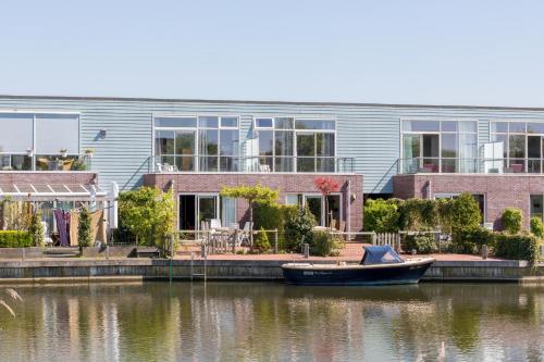 a boat in the water in front of a building at Nautic Rentals - Marinapark Oude-Tonge in Oude-Tonge