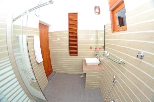 a bathroom with a sink and a glass shower at Sethum Villa in Unawatuna