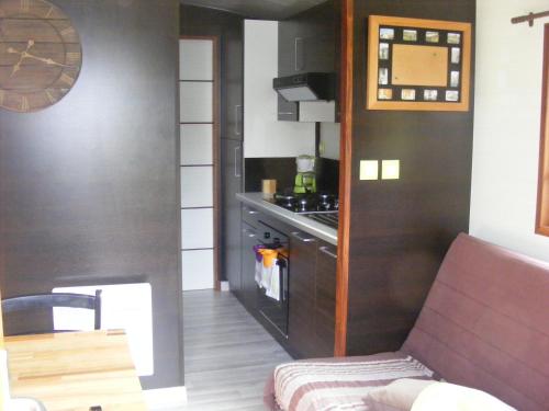 Il comprend une petite cuisine équipée d'une cuisinière et d'un comptoir. dans l'établissement Un séjour à la Roulotte, à Écault