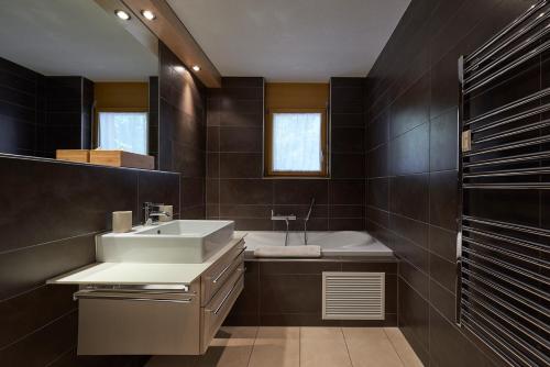 uma casa de banho com um lavatório e uma banheira em Haus Bor em Zermatt