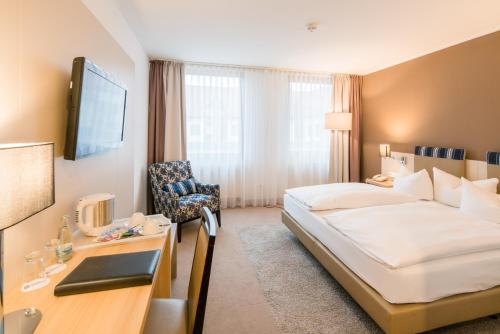 ein Hotelzimmer mit einem Bett und einem Schreibtisch in der Unterkunft Best Western Erfurt-Apfelstädt in Erfurt