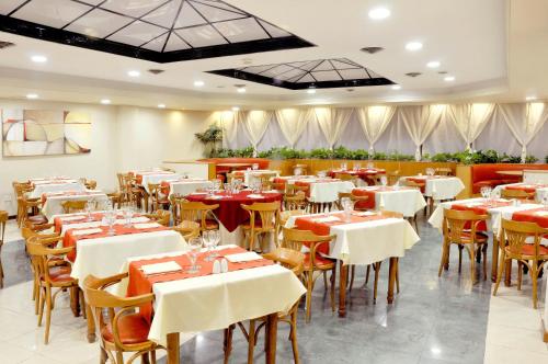 a dining room with white tables and chairs at Hotel Argos in Bahía Blanca