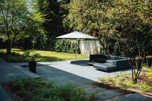 a park with a bench and an umbrella at HK Hotel Düsseldorf City in Düsseldorf