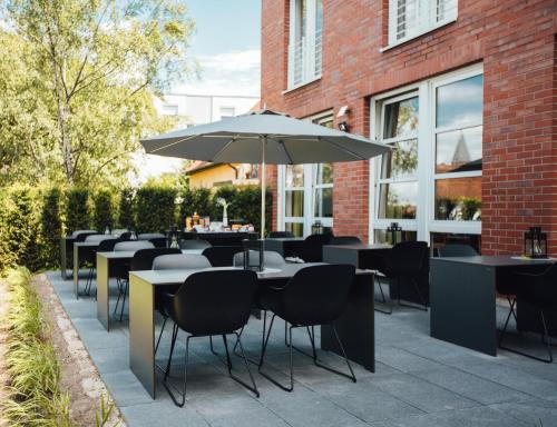 a group of tables and chairs with an umbrella at HK Hotel Düsseldorf City in Düsseldorf