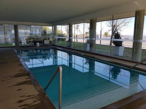 a swimming pool in the middle of a building at Apart Altos del Virrey in Colonia del Sacramento