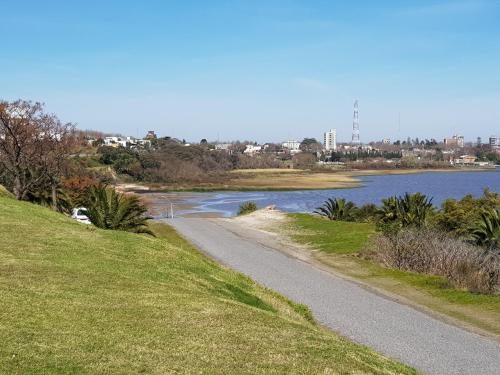 a dirt road next to a body of water at Apart Altos del Virrey in Colonia del Sacramento