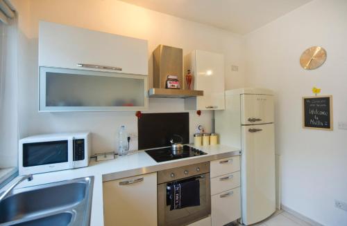 Una pequeña cocina con microondas y nevera. en BM1 - Blue Marine Apartment, en San Julián