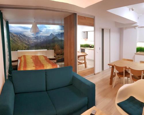 a living room with a bed and a dining room at Apartamenty nad potokiem in Zakopane