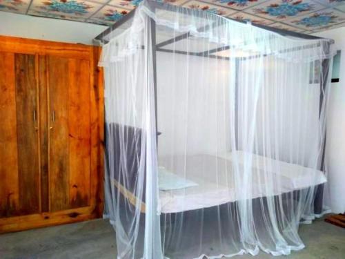 a bed with a canopy in a room at Parei Beach Inn in Tangalle