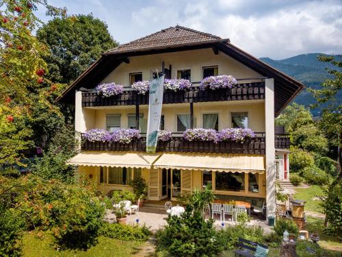 una casa con un balcón con flores. en Bavaria Biohotel en Garmisch-Partenkirchen