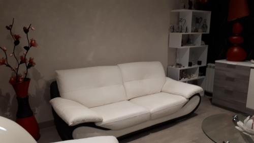 un sofá blanco en una sala de estar con mesa en 25 Rue Raymond Braillard en Dole