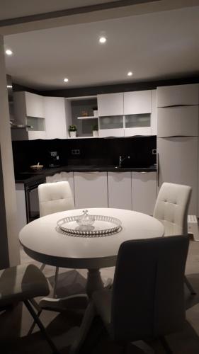 a white table and chairs in a kitchen at 25 Rue Raymond Braillard in Dole