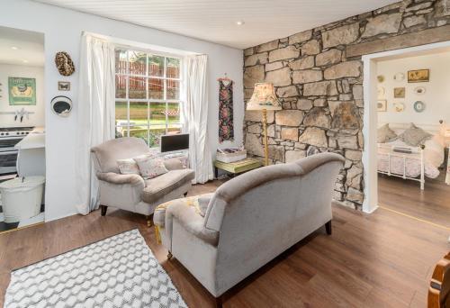een woonkamer met 2 stoelen en een stenen muur bij VINTAGE apt, pvt GARDEN, wifi, NEW TOWN in Edinburgh