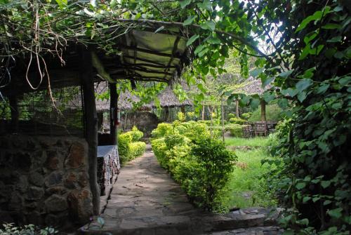 an old stone building with a walkway in a garden at Osoita Lodge in Nairobi