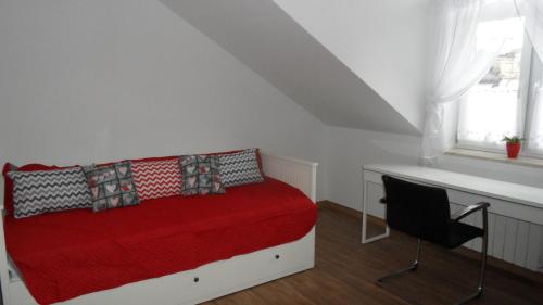 a bedroom with a red bed and a chair at Nowy Apartament CENTRUM - faktura VAT in Włodawa