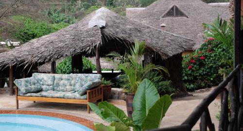 a couch sitting in front of a thatch hut at Osoita Lodge in Nairobi