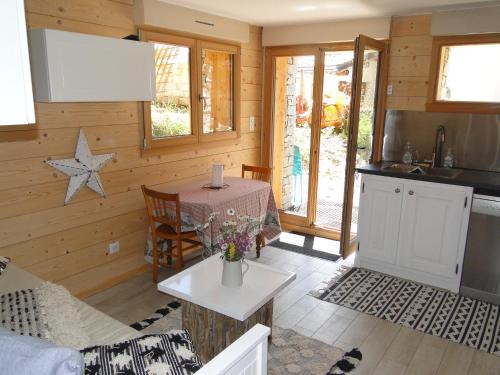 a kitchen and living room with a table and a counter at La Coulée Douce in Lanslevillard