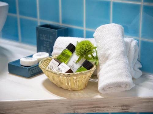 帕勞的住宿－帕勞酒店，浴室柜台上的洗浴用品和毛巾篮