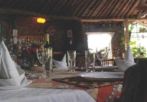a table with a white plate and wine glasses at Osoita Lodge in Nairobi
