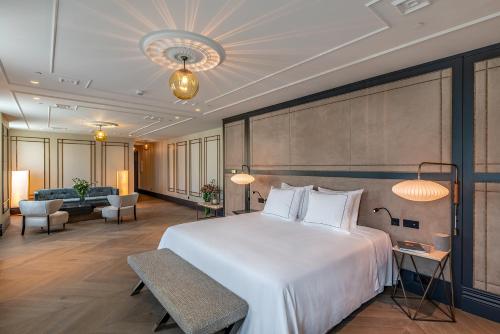 ein Hotelzimmer mit einem großen Bett und einem Wohnzimmer in der Unterkunft CoolRooms Palacio de Atocha in Madrid