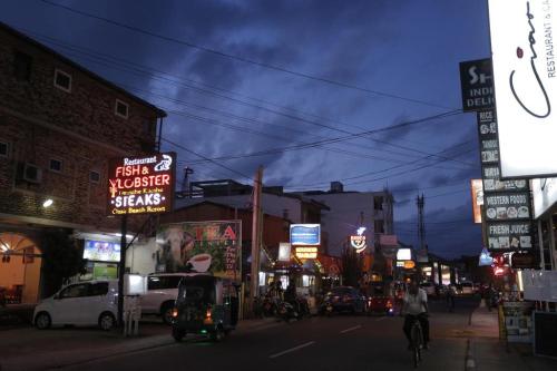 a busy city street at night with neon signs at Marine Hostel at Negombo Beach Near Airport in Negombo