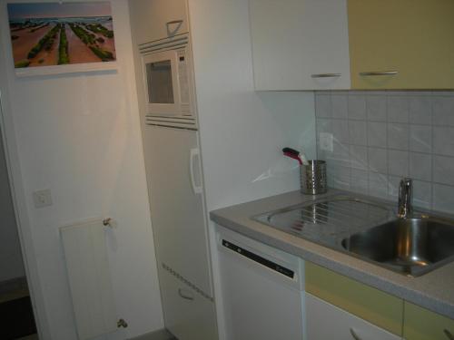 a small kitchen with a sink and a microwave at Ferienapartment Davos in Davos