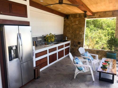 a kitchen with a refrigerator and a table and chairs at Romantic Beachfront Retreat in San Juan del Sur