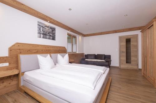 a bedroom with a large white bed and a chair at Altroiterhof in St. Wolfgang