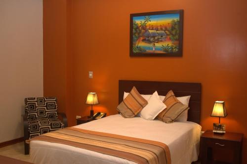 a bedroom with a bed and a painting on the wall at Hotel Europa in Iquitos