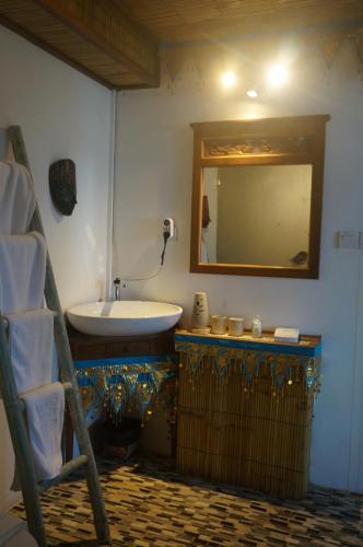 a bathroom with a sink and a mirror at Manggis Garden Dive Resort in Candidasa