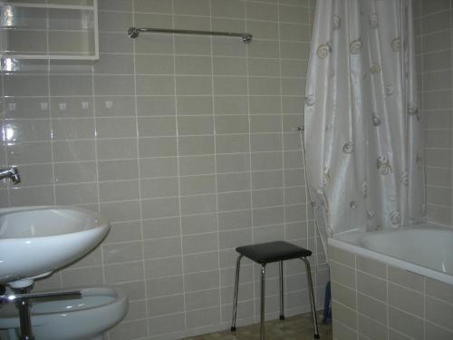 a bathroom with a sink and a toilet and a bath tub at Ferienapartment Davos in Davos