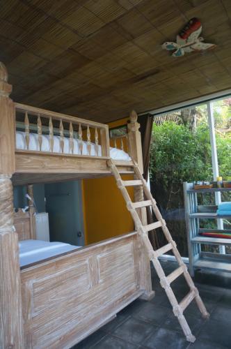 a bunk bed with a ladder in a room at Manggis Garden Dive Resort in Candidasa
