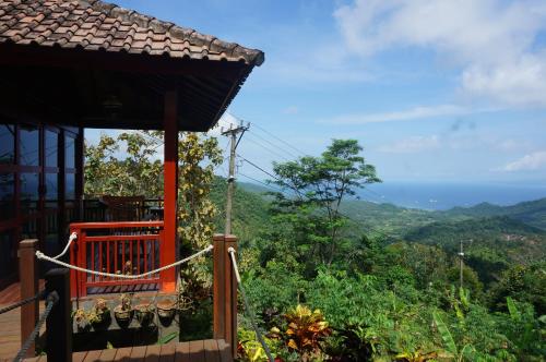 a balcony of a house with a view of the mountains at Manggis Garden Dive Resort in Candidasa