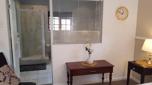 a room with a vase on a table and a clock at Walmer Heights Guest House in Port Elizabeth