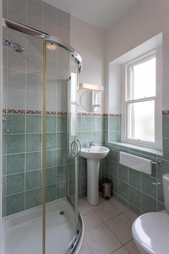 a bathroom with a shower and a sink and a toilet at Berkeley House in Keswick