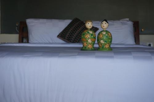 two figurines sitting on top of a bed at Manggis Garden Dive Resort in Candidasa