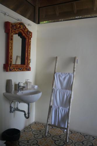 a bathroom with a sink and a mirror at Manggis Garden Dive Resort in Candidasa