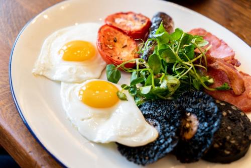a plate of eggs and vegetables on a table at Arrow Mill- Brunning and Price in Alcester