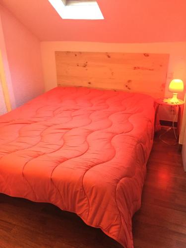 リュス・サン・ソヴァールにあるLoc luz st sauveur 1のベッドルーム1室(大型ベッド1台、オレンジ色のベッドカバー付)