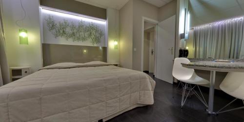 - une chambre avec un lit, une table et des chaises dans l'établissement Hotel Glenmore, à Ostende