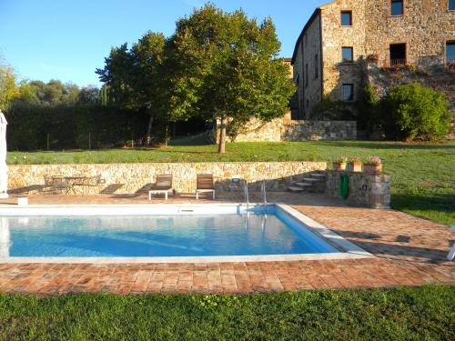 a swimming pool in the yard of a house at Agriturismo Tenuta il Tasso in Rapolano Terme