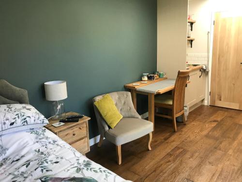 a bedroom with a bed and a desk with a chair at Corner House Luxury BnB in Little Dunmow