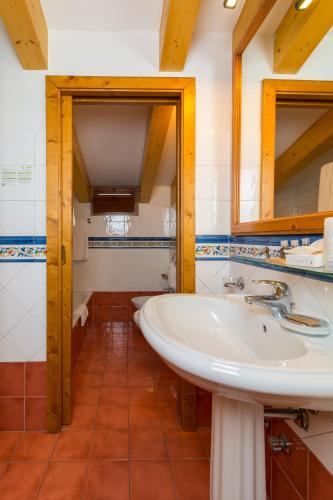 a bathroom with a sink and two mirrors at Hotel Bonapace ***S in Madonna di Campiglio