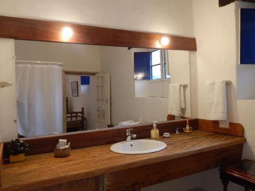 uma casa de banho com um lavatório e um espelho grande em Posada El Molino de San Luis em Ubaté